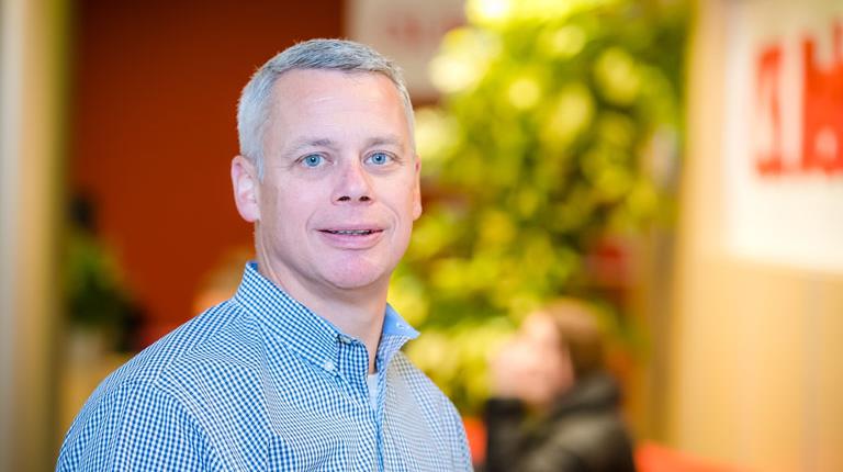 Photo of Brian Dudt looking straight ahead and smiling